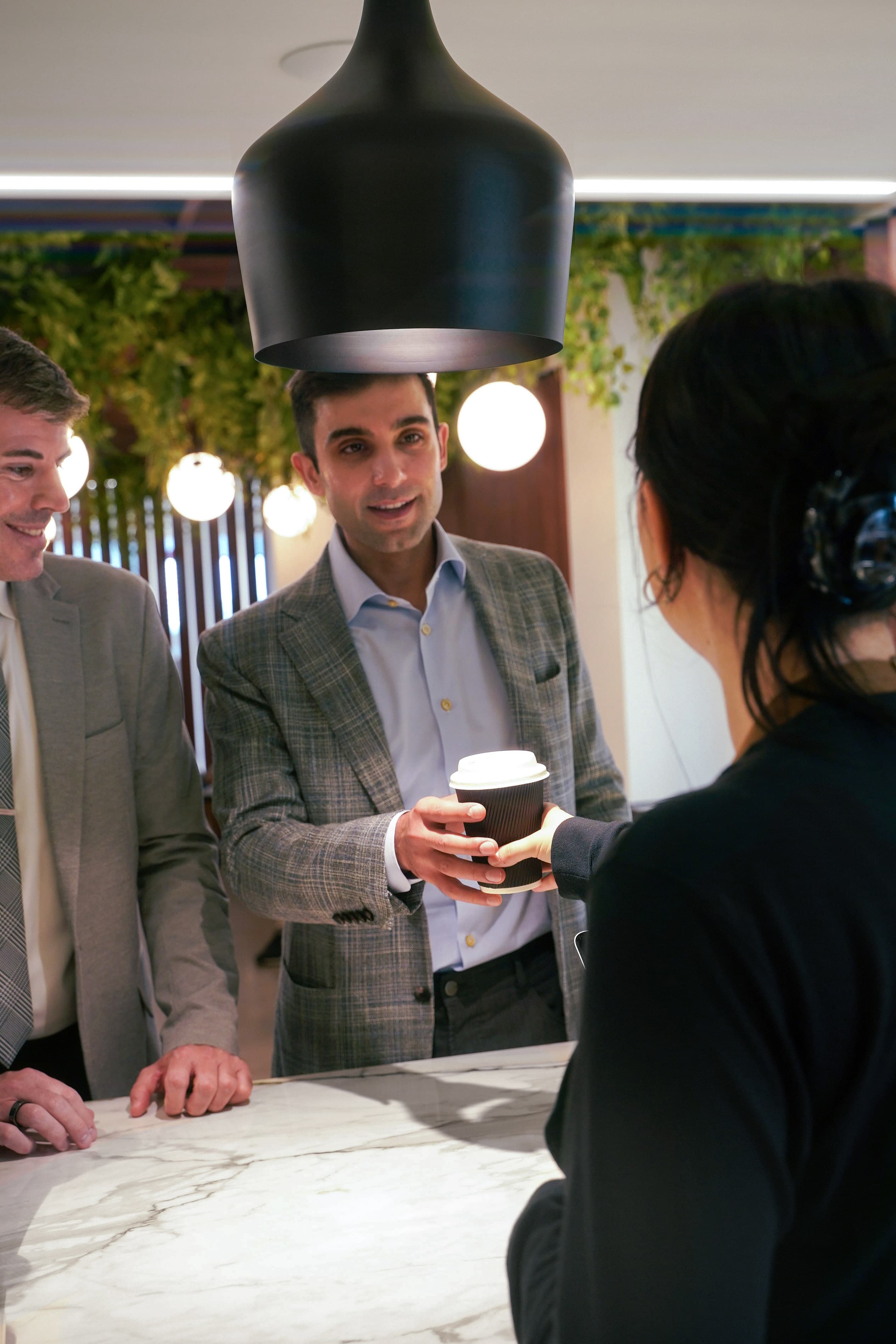 Barista handing coffee to a customer at Café 295