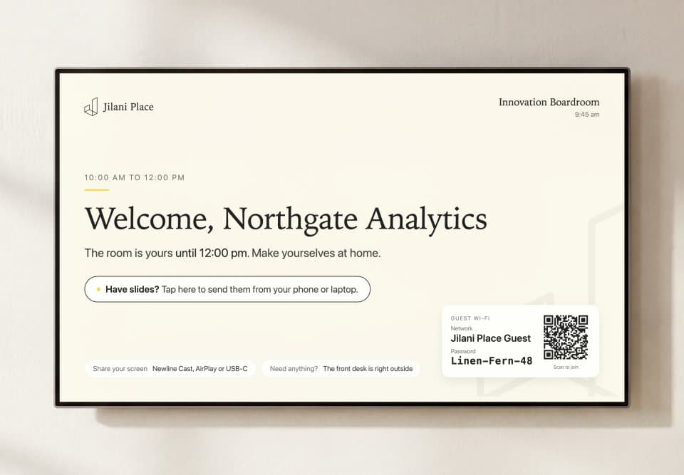 The Smart Boardroom screen welcoming a company by name, with the guest Wi-Fi shown
